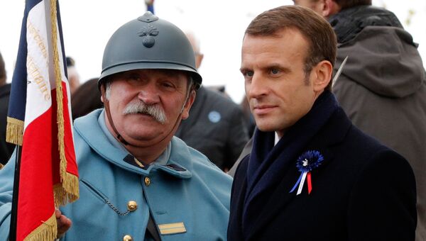 Президент Франции Эммануэль Макрон и реконструктор, одетый как солдат французской армии времен Первой мировой войны, во время памятной церемонии в коммуне Моранж. 6 ноября 2018