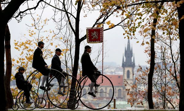Участники в исторических костюмах на велосипедах во время ежегодной гонки пенни фартинг в Праге, Чешская Республика. 3 ноября 2018 года