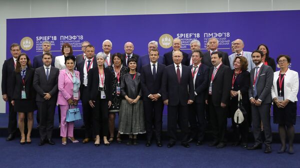 Владимир Путин и Эммануэль Макрон во время совместного фотографирования с членами координационного совета Трианонский диалог
