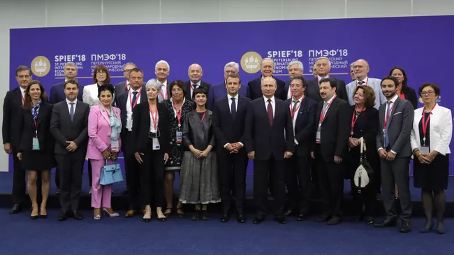 Владимир Путин и Эммануэль Макрон во время совместного фотографирования с членами координационного совета Трианонский диалог