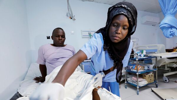 Фельдшер в госпитале осматривает человека, получившего ранения во взрыва около отеля в Могадишо, Сомали. 10 ноября 2018