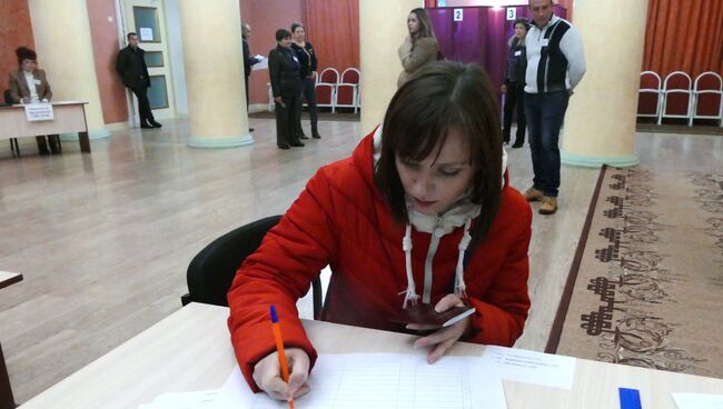 Девушка расписывается в списке избирателей во время голосования на выборах главы ДНР и депутатов Народного совета ДНР на избирательном участке в Донецке. 11 ноября 2018