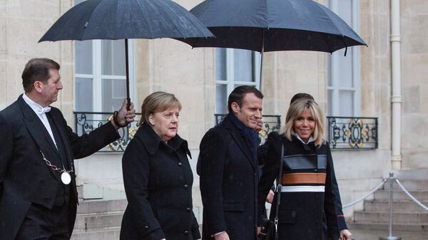 Канцлер ФРГ Ангела Меркель, президент Франции Эммануэль Макрон и его супруга Бриджит выходят из Елисейского дворца перед началом мероприятий, посвященных 100-летию окончания Первой мировой войны. 11 ноября 2018 