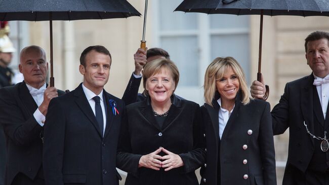 Президент Франции Эммануэль Макрон, канцлер ФРГ Ангела Меркель и супруга президента Франции Бриджит Макрон у Елисейского дворца перед началом мероприятий, посвященных 100-летию окончания Первой мировой войны.