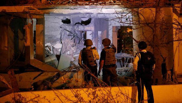 Сотрудники службы безопасности проверяют дома в израильском городе Ашкелоне после ракетной атаки из сектора Газы. 12 ноября 2018