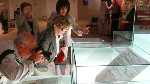 Посетители рассматривают экспонаты на выставке. Архивное фото