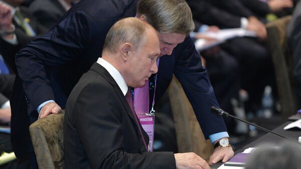 Президент России Владимир Путин  и помощник президента Юрий Ушаков на пленарном заседании Восточноазиатского саммита в Сингапуре. 15 ноября 2018