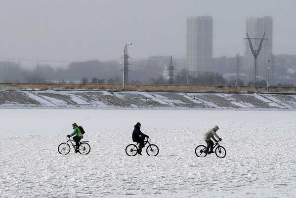 Люди гуляют на льду замерзшего водохранилища Новосибирской ГЭС
