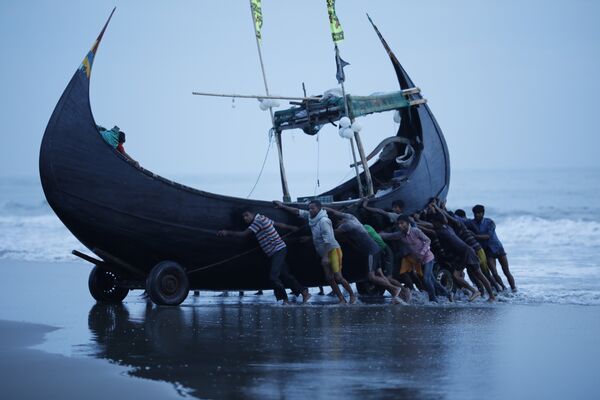 Рыбаки у лодки у берегов деревни Текнаф, Бангладеш 
