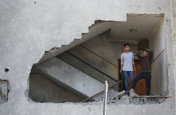 Молодые люди в жилом доме, пострадавшем от ракетного удара Израиля по территории сектора Газа