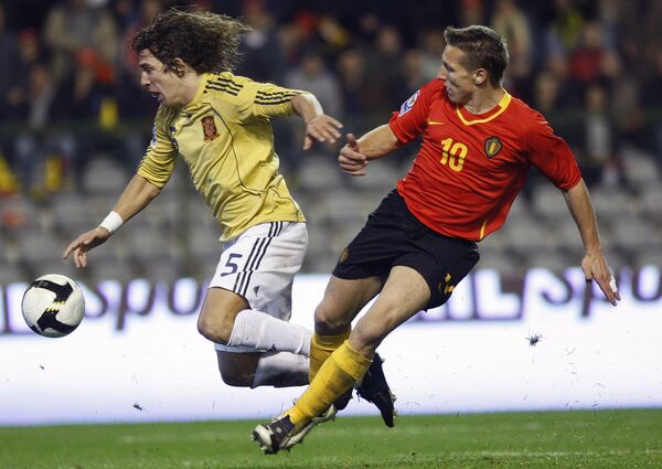 Карлос Пуйоль (слева) против Уэсли Сонка в отборочном матче ЧМ-2010 Бельгия - Испания
