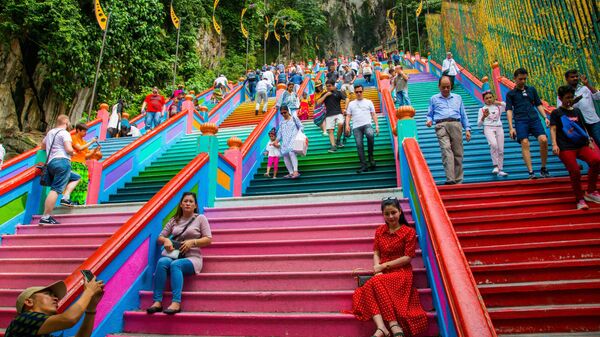 Туристы фотографируются на лестнице, ведущей в пещеры Бату в Куала-Лумпуре