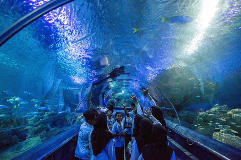 Посетители в океанариуме Куала-Лумпура (Aquaria KLCC) расположенном в самом центре города на нижнем уровне башен-близнецов Петронас