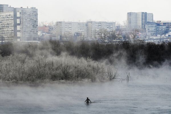 Рыбак в гидрокостюме ловит рыбу на протоке Татышева в Красноярске