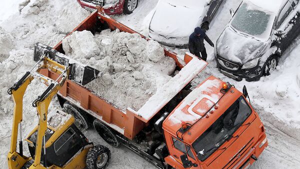 Погрузка снега в кузов грузового автомобиля. Архивное фото