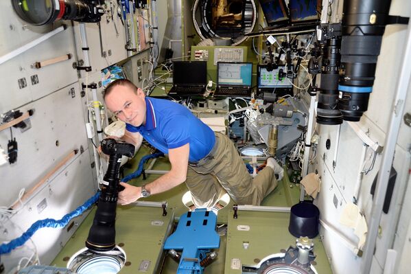 Космонавт Роскосмоса Сергей Рязанский фотографирует на борту МКС