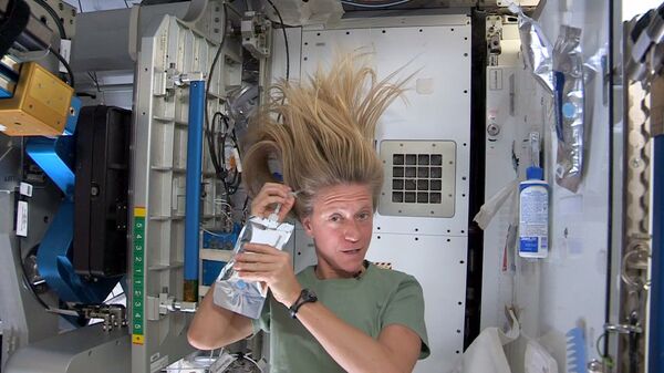 Астронавт Карен Найберг моет голову на борту МКС