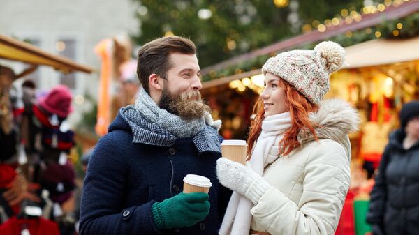 Счастливая пара пьет кофе на улице 