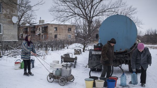 Местные жители набирают воду из цистерны в поселке Донецкий Луганской области