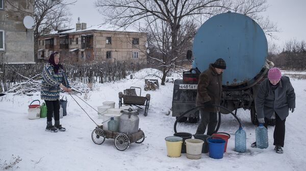 Местные жители набирают воду из цистерны в поселке Донецкий Луганской области