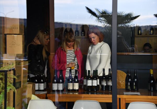 Посетители фестиваля «WineFest» в Балаклаве рассматривают бутылки с вином Посетители фестиваля «WineFest» в Балаклаве рассматривают бутылки с вином