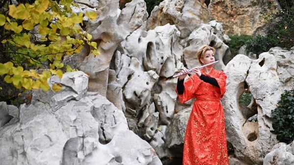 Артистка играет на флейте на открытии Японского сада на территории парка Айвазовское