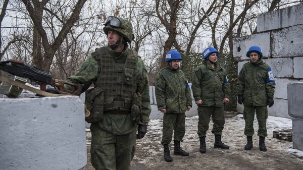 Военнослужащий ЛНР и наблюдатели ОБСЕ на контрольно-пропускном пункте в районе Станицы Луганской