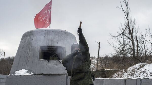 Военнослужащий ЛНР запускает сигнальную ракету для подтверждения со стороны Украины разведения сил и средств на контрольно-пропускном пункте в районе Станицы Луганской