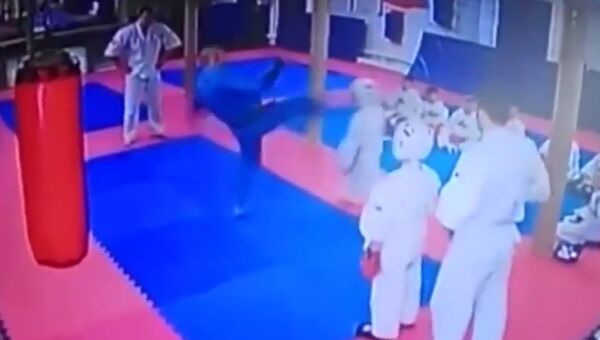 Скриншот видео с занятия кудо, где тренер Иван Кирилко ударил ребенка ногой