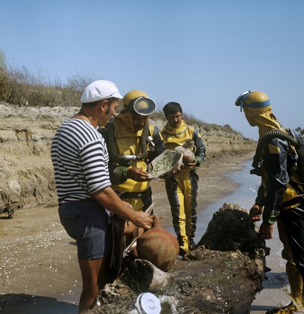 Начальник экспедиции Каспийская Атлантида Виктор Квачидзе (слева) с коллегами рассматривает находки, поднятые со дня моря.