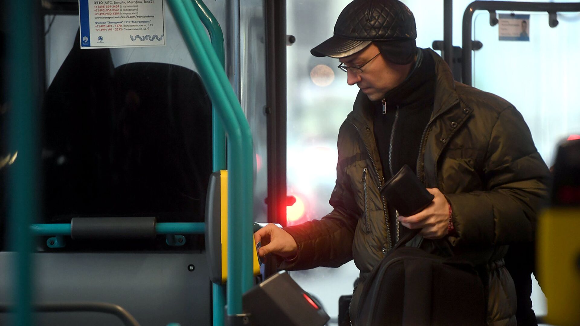 Пассажир оплачивает проезд в автобусе - РИА Новости, 1920, 11.01.2021