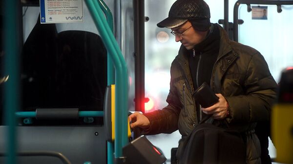 Пассажир оплачивает проезд в автобусе