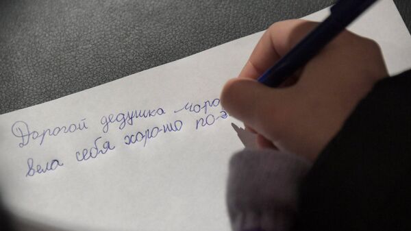 Ребенок пишет письмо Деду Морозу на почте в Московском зоопарке