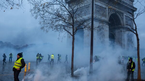 Участники протестной акции движения автомобилистов желтые жилеты, выступавшего с требованием снижения налогов на топливо, в районе Триумфальной арки в Париже