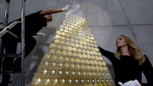 Сотрудники компании ProAurum украшают рождественскую елку из золотых монет общей стоимостью 2,3 миллиона евро в Мюнхене, Германия. 3 декабря 2018