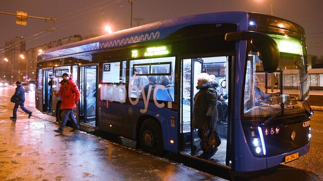 Пассажиры выходят из электробуса, следующего по маршруту № 73 в Москве 