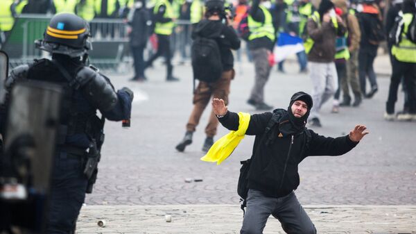 Сотрудник правоохранительных органов и активист во время протестной акции движения желтые жилеты в Париже. Архивное фото