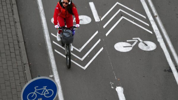 Девушка едет на велосипеде по улице в Москве. Архивное фото
