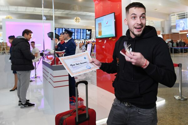 Пассажир с призом лотереи, проходящей во время акции Я делаю добро в России в терминале D аэропорта Шереметьево в Национальный день добровольца