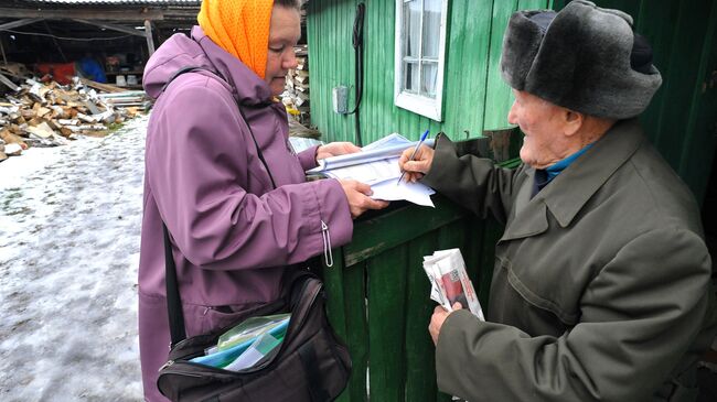 Житель деревни Татарская Караболка Кунашакского района Челябинской области расписывается за полученное ежемесячное денежное пособие