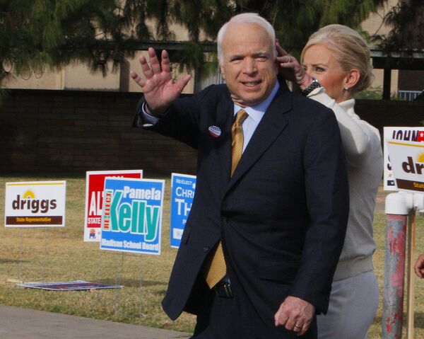 Джон Маккейн приветствует публику возле своего избирательного участка