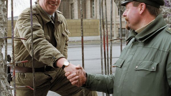 Пограничник из ГДР и полицейский из ФРГ обмениваются рукопожатием. Архив