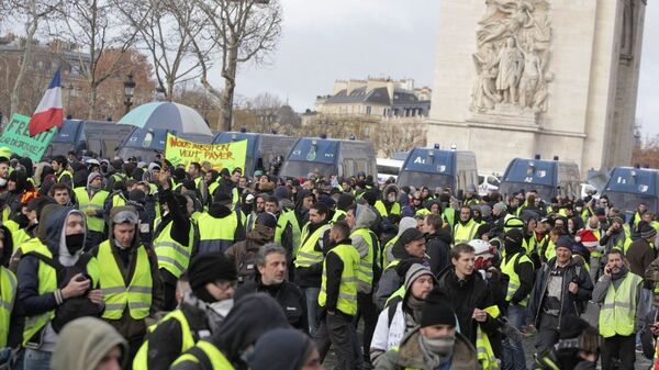Участники акции протеста движения автомобилистов желтые жилеты в районе Триумфальной арки в Париже.  8 декабря 2018