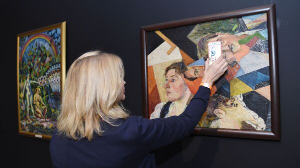 Посетительница на выставке в Музее русского импрессионизма у картины Давида Бурлюка Семейный портрет