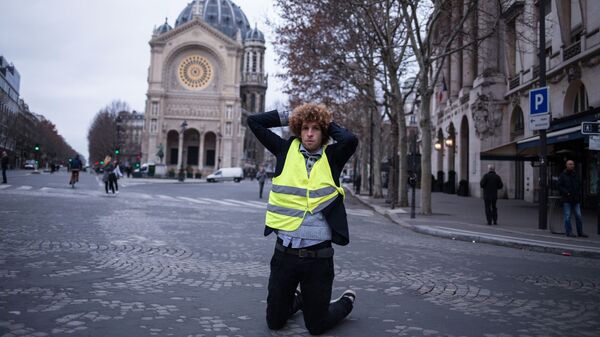 Участник акции протеста движения автомобилистов желтые жилеты в районе Триумфальной арки в Париже