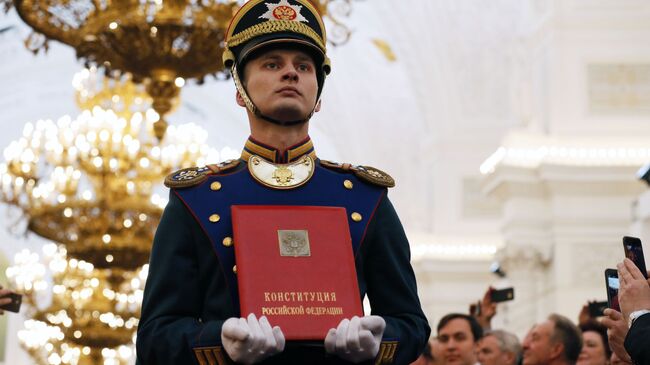 Солдат Президентского полка вносит специальный экземпляр Конституции России на церемонии инаугурации президента России Владимира Путина в Кремле. 7 мая 2018 