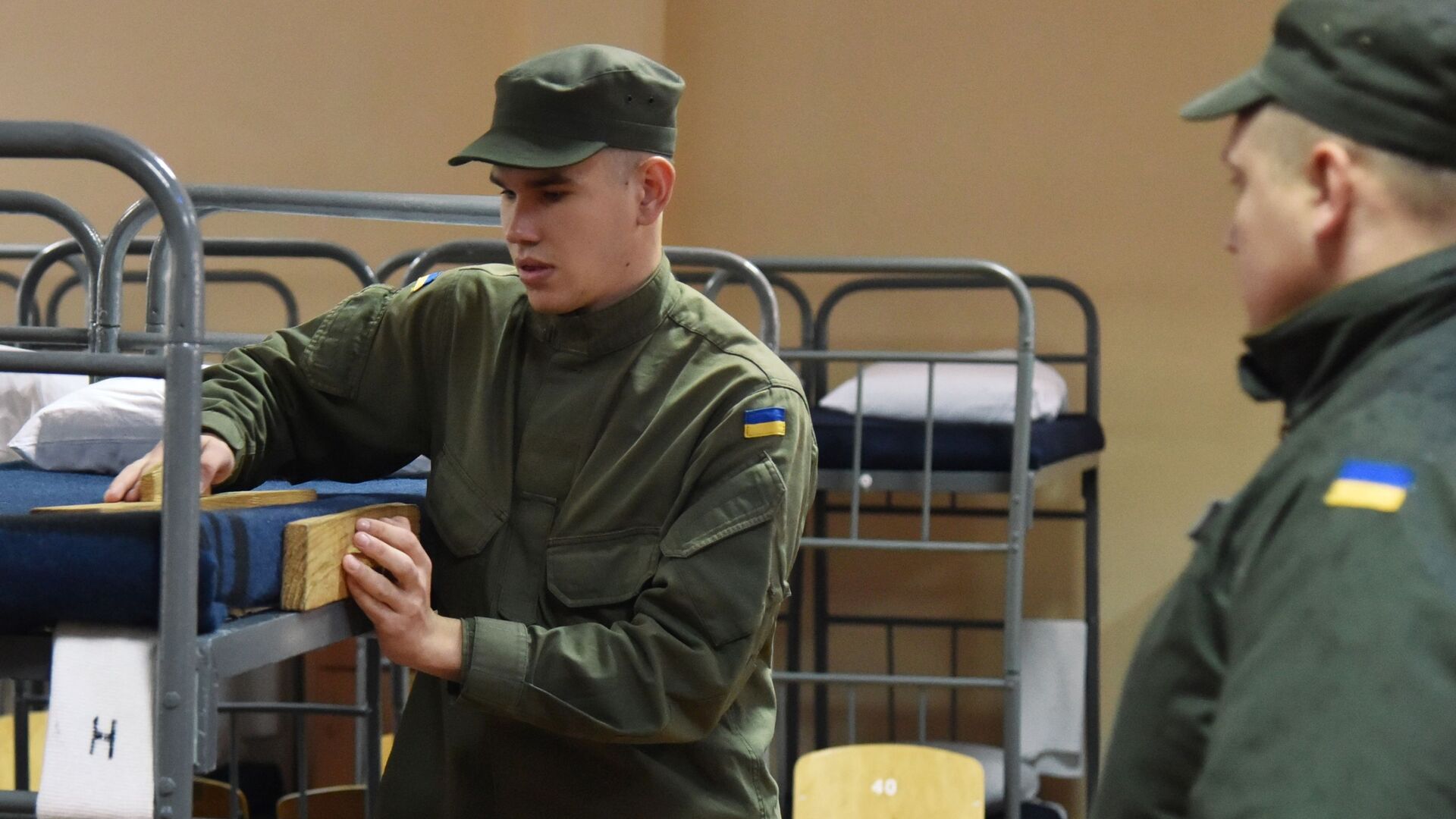 Военнослужащий заправляет кровать в казарме одной из воинских частей Нацгвардии Украины во Львове - РИА Новости, 1920, 12.08.2022