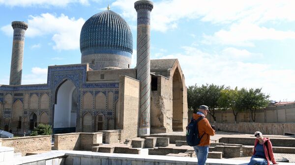 Туристы фотографируются у мавзолея Гур-Эмир в Самарканде, Узбекистан