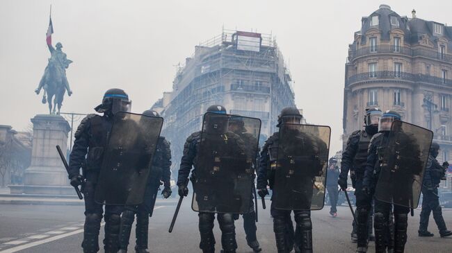 Сотрудники полиции во время акции протеста желтые жилеты в Париже. 16 декабря 2018 