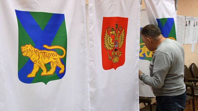 Мужчина голосует на повторных выборах губернатора Приморского края на избирательном участке во Владивостоке. 16 декабря 2018